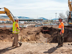men in safety vests working on a construction site