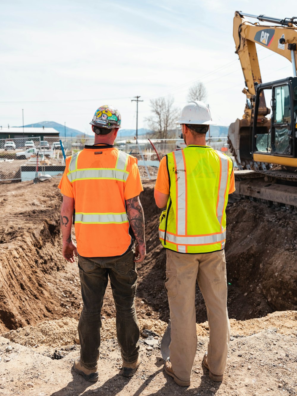 men in safety vests standing in front of a construction vehicle