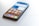 A smartphone placed on a light surface displaying a variety of app icons on the home screen. The phone has a sleek design with an edge-to-edge display. Notable apps include TikTok, Facebook, Instagram, and WhatsApp.