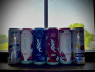 Brightly colored energy drinks lined up on a store shelf.