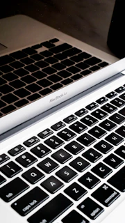 Close-up of a MacBook keyboard being serviced by a focused technician.