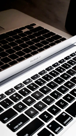 Close-up of a MacBook keyboard being serviced by a focused technician.