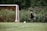 A young soccer player in black and gold uniform celebrating a goal on the field.