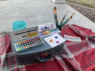 A cozy paint night setup with brushes, canvases, and bright red supplies ready for a creative gathering.