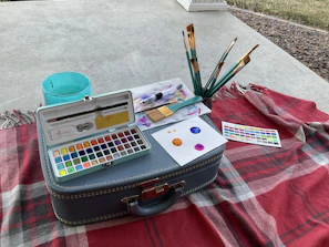 Organized painting tools laid out neatly on a bright green protective tarp