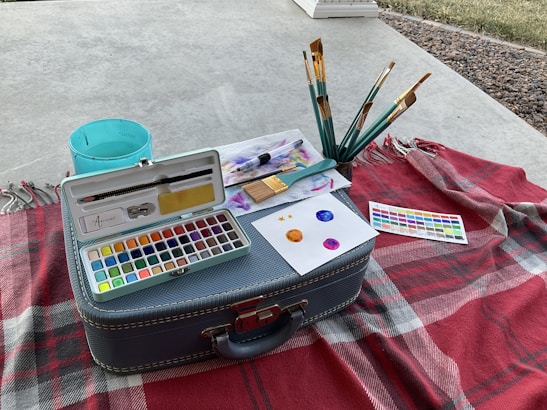 A mobile painting setup with easels and colorful paints in an outdoor setting.