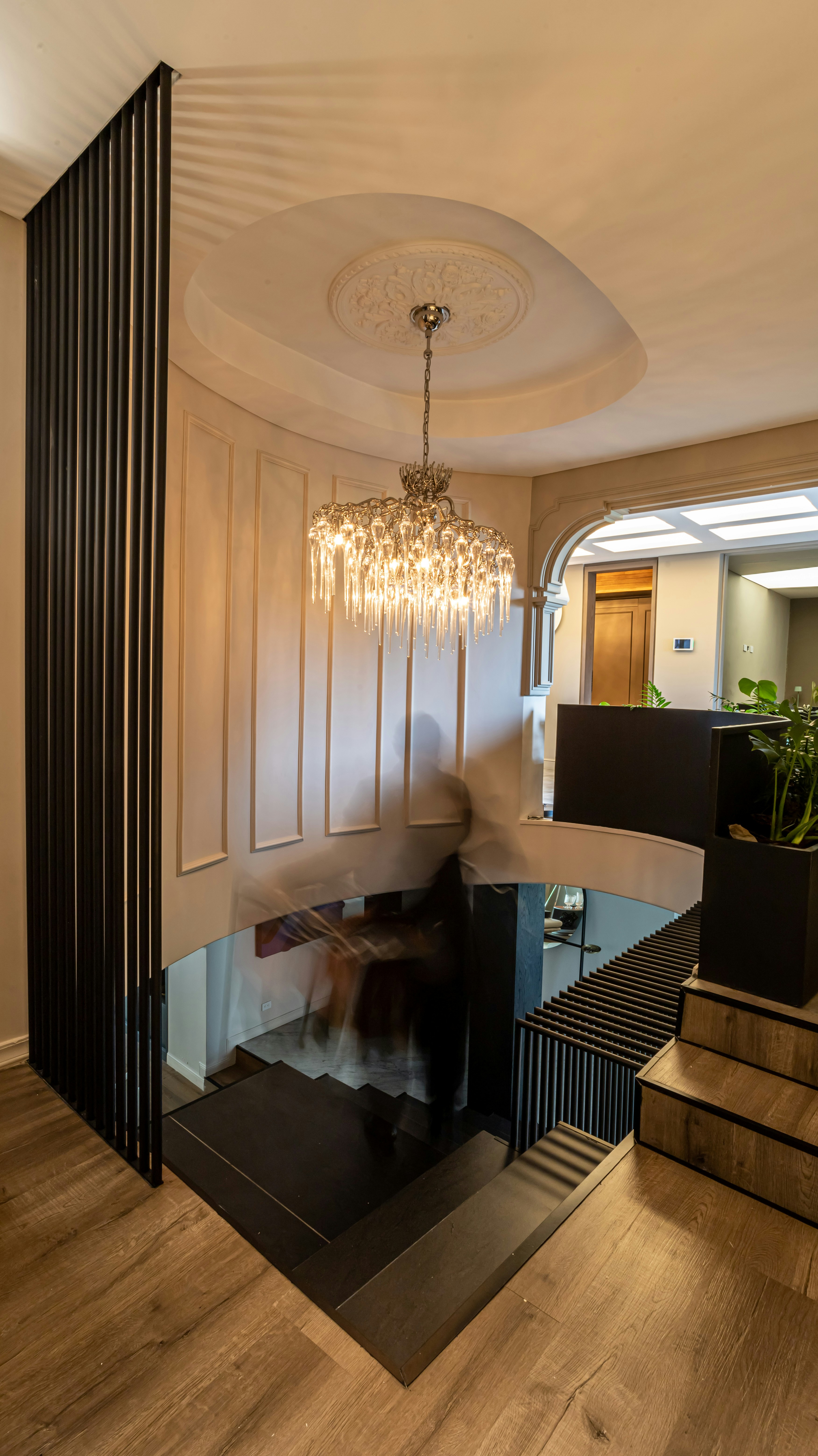 um lustre de um teto em uma sala com um piso de madeira e um piso de madeira