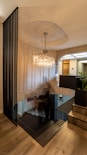 a chandelier from a ceiling in a room with a wood floor and a wood floor