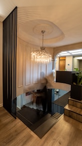 a chandelier from a ceiling in a room with a wood floor and a wood floor