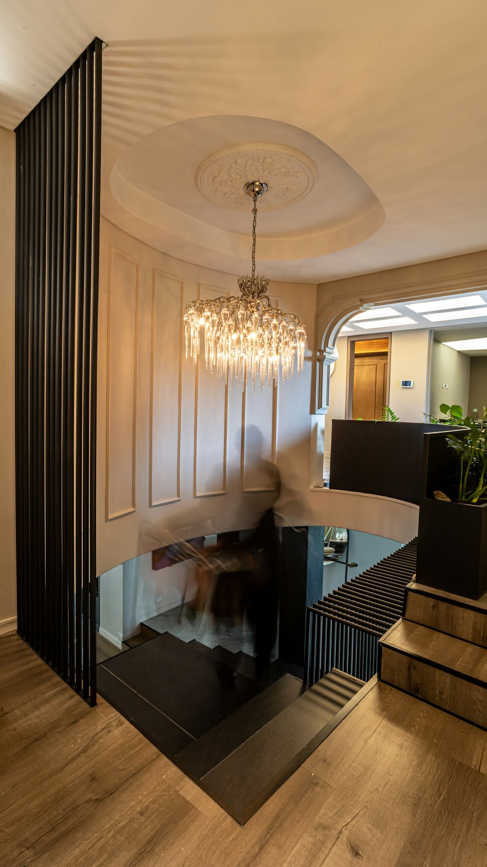 a chandelier from a ceiling in a room with a wood floor and a wood floor