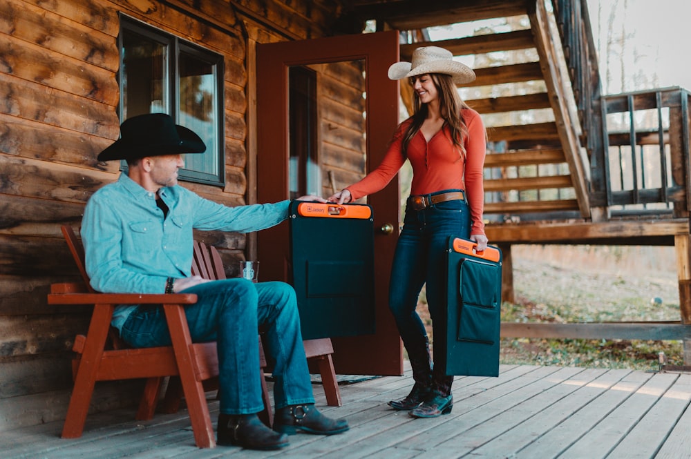 Una mujer y un hombre con sombreros de vaquero en un porche