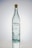 A tall, clear glass bottle with a cork stopper. The bottle has bubbles trapped within the glass and a label featuring the brand name 'Porfidio'. The text indicates it's made from 100% blue agave, cold-pressed, and triple-distilled.