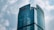 A modern skyscraper with a curved glass facade, prominently displaying the HNA logo at the top. The building rises against a backdrop of a cloudy sky, showcasing a blend of architectural innovation and corporate branding.