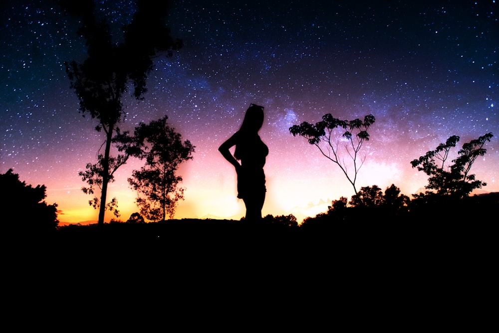 a silhouette of a man and trees