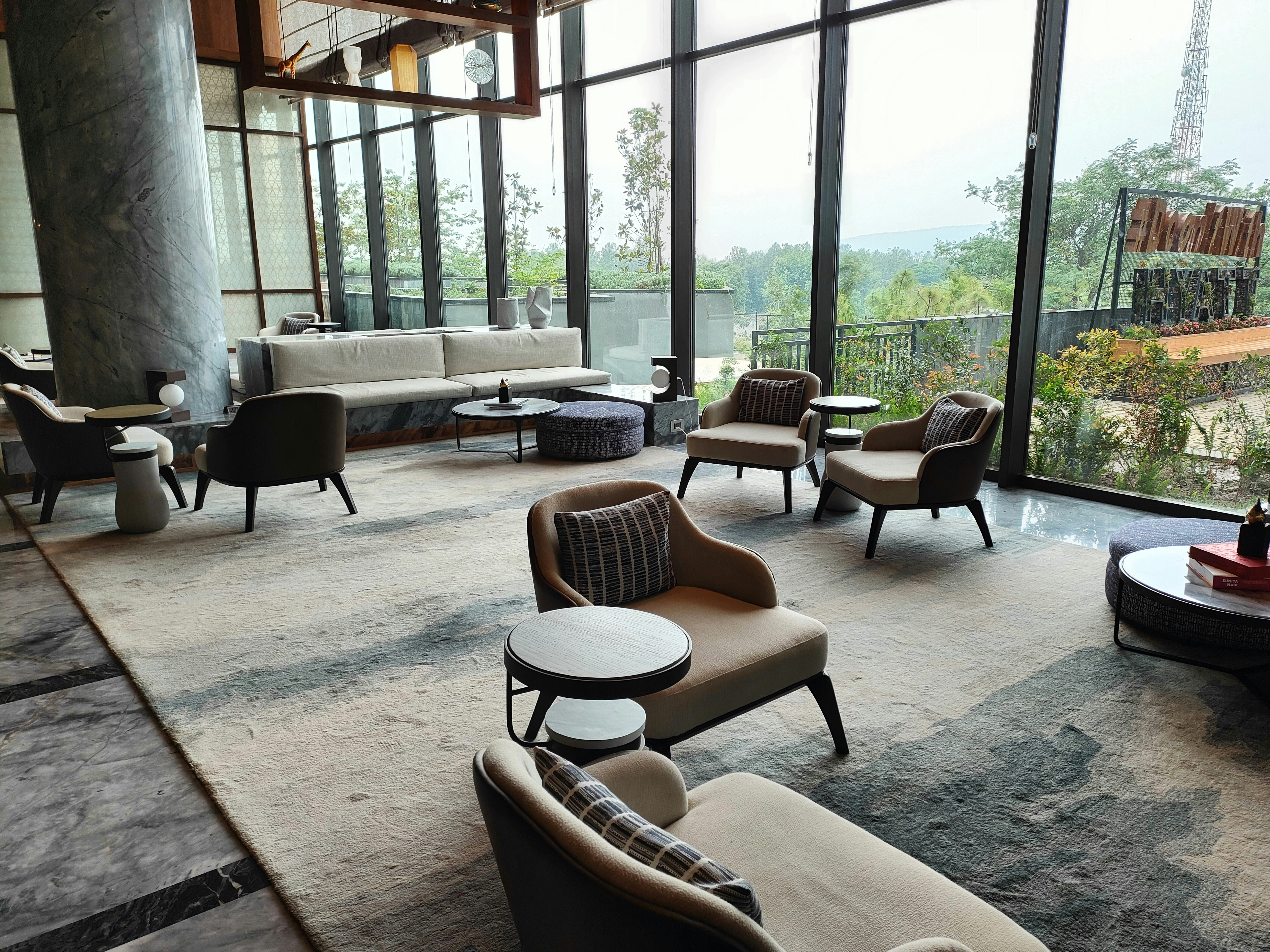 Modern lounge area with seating overlooking a green landscape.