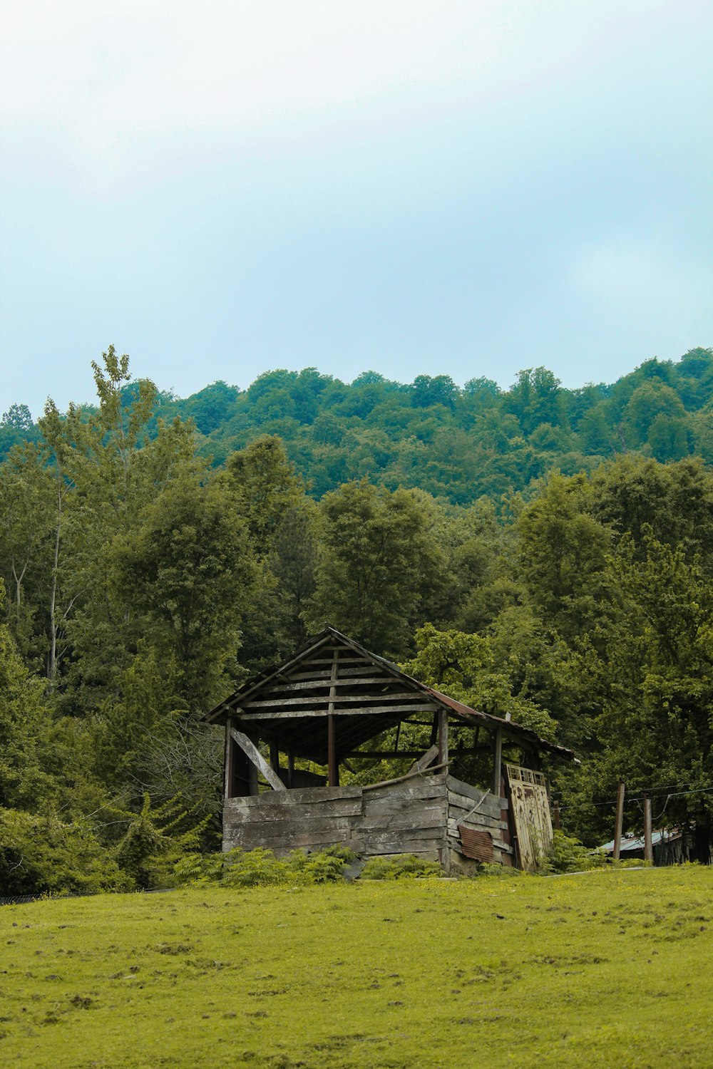 a wooden building in a field