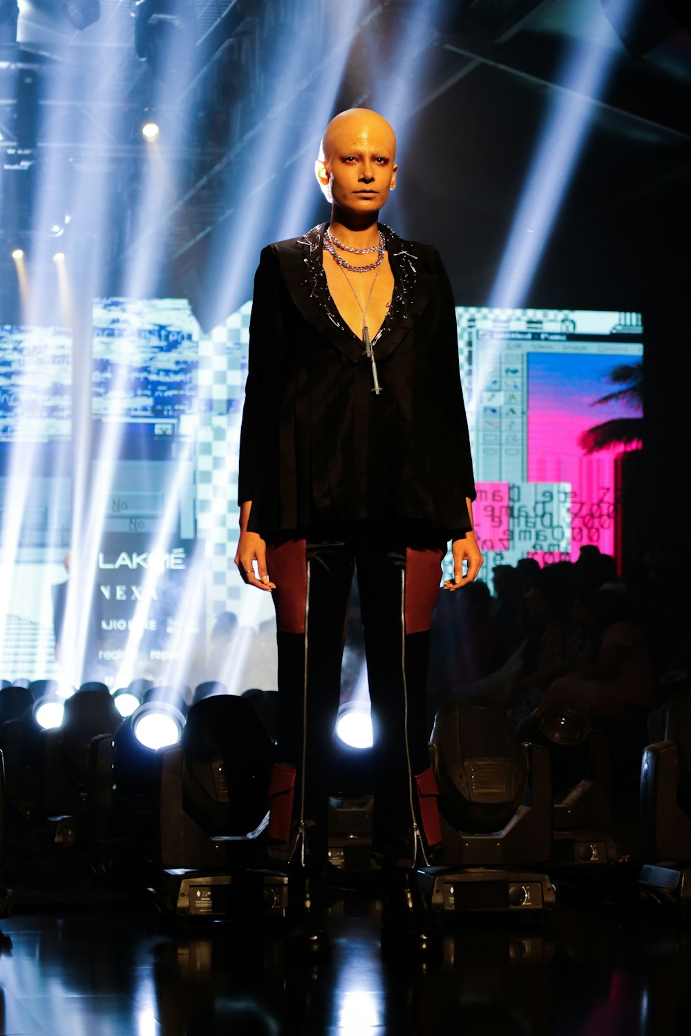 a mannequin wearing a black suit and gold necklace