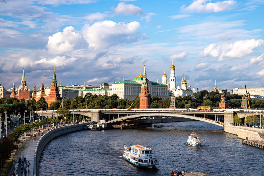 Cremlino di Mosca su un fiume con una barca su di esso e un grande edificio sullo sfondo