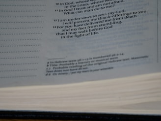 A close-up view of an open book showing printed text on the pages. The text is primarily in black ink and includes headings and footnotes. The image captures the texture of the pages and the layout of the printed lines.