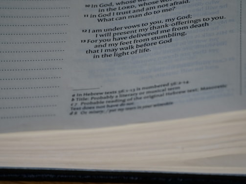 A close-up view of an open book showing printed text on the pages. The text is primarily in black ink and includes headings and footnotes. The image captures the texture of the pages and the layout of the printed lines.