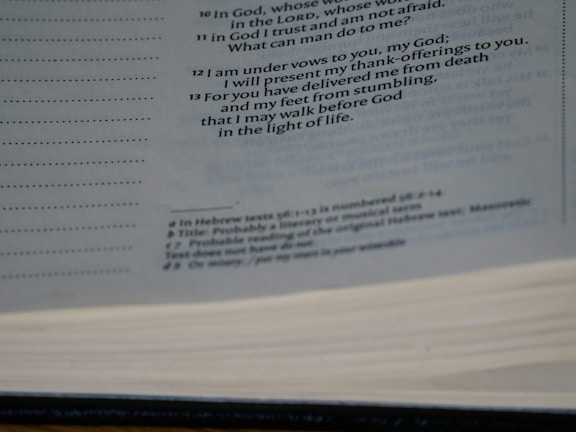 A close-up view of an open book showing printed text on the pages. The text is primarily in black ink and includes headings and footnotes. The image captures the texture of the pages and the layout of the printed lines.