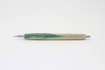 Close-up of a sleek emerald green promotional pen with golden accents on a clean white background.