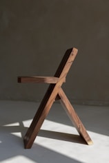 a wooden chair on a white surface