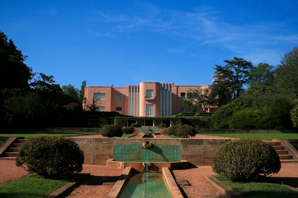 Un gran edificio con una piscina frente a él