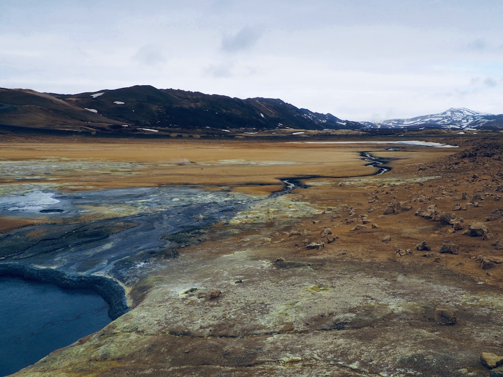 Una gran área de tierra con agua y montañas al fondo