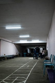 a group of people standing in a room with a tile floor