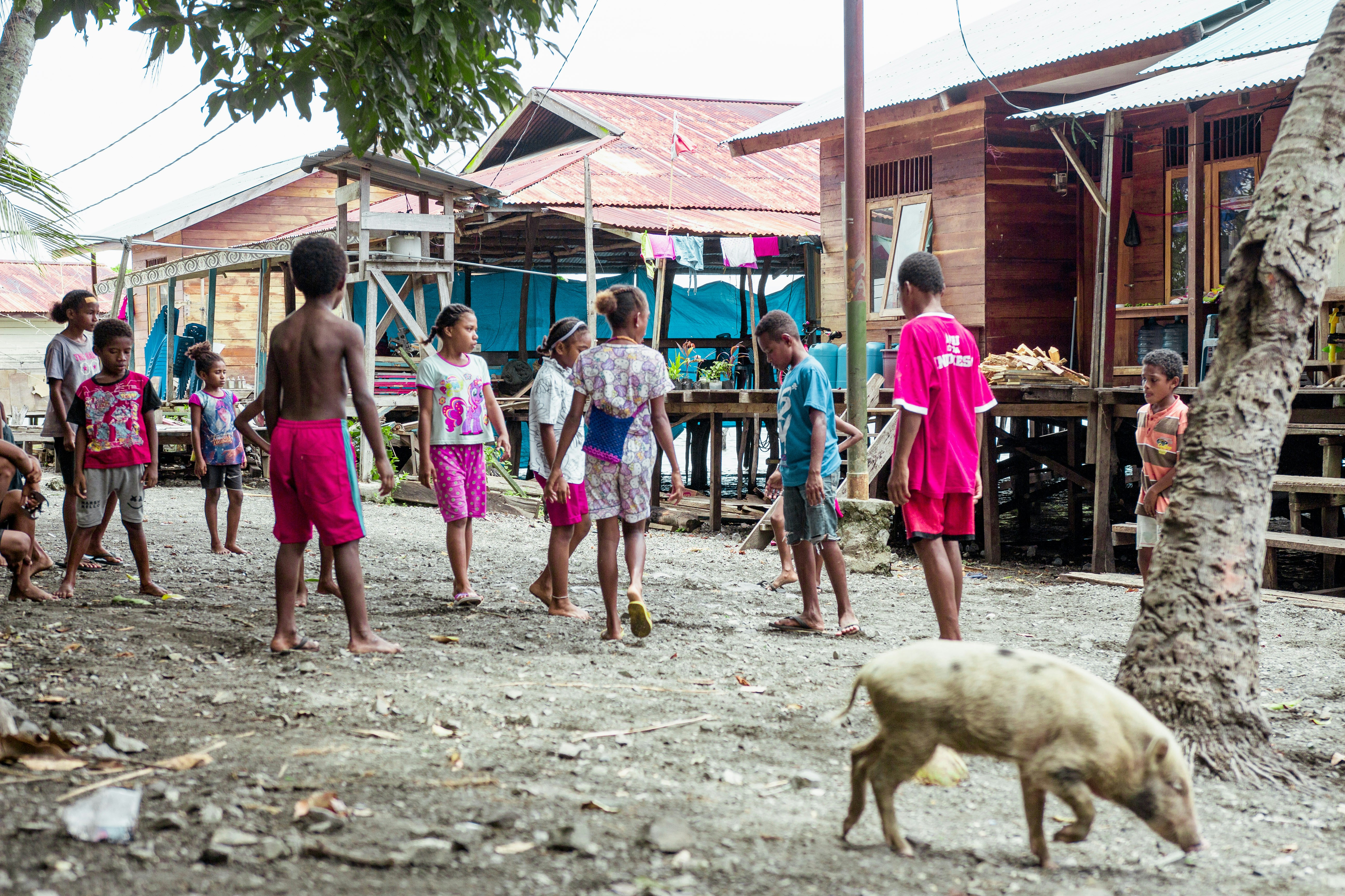 Family with children enjoying village activities and interacting with farm animals at homestay