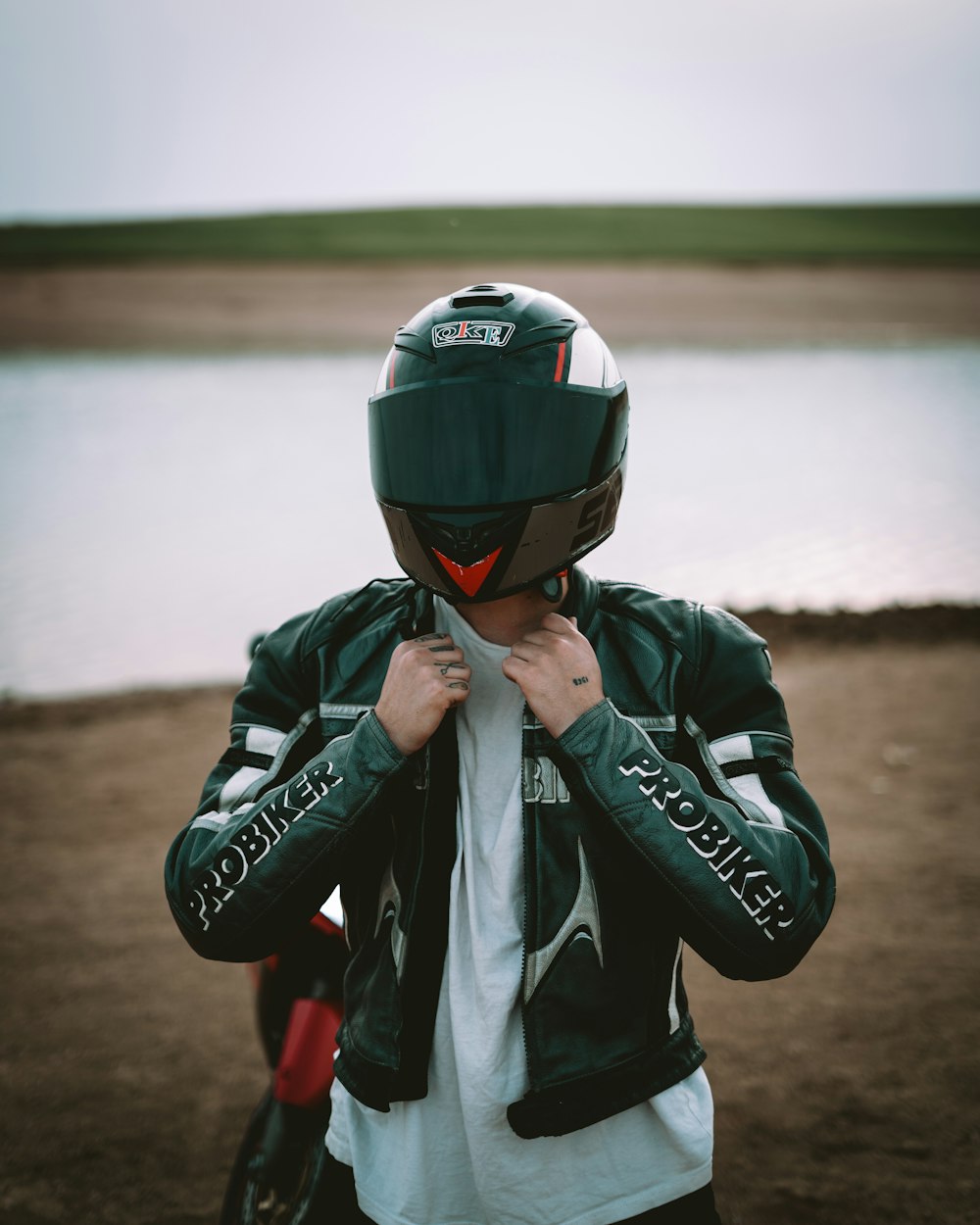 a man wearing a helmet and holding his hand to his face