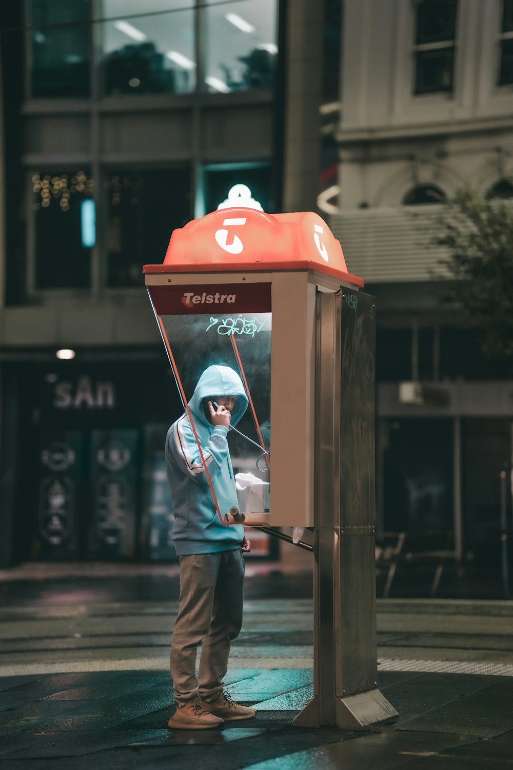 a man standing next to a telephone booth