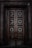 Close-up of a richly detailed 3D carved wooden door with intricate floral patterns.