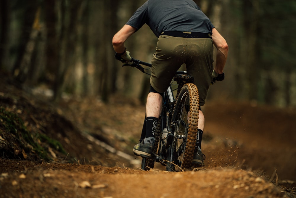 a man riding a bike down a dirt road