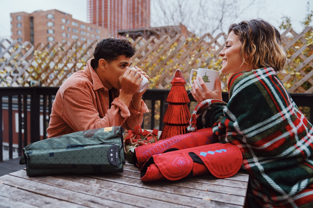 a man and woman sitting on a bench with a statue of a man