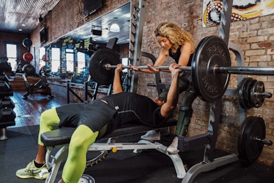 A man and a woman working out together in the gym for the Body Building fitness podcast