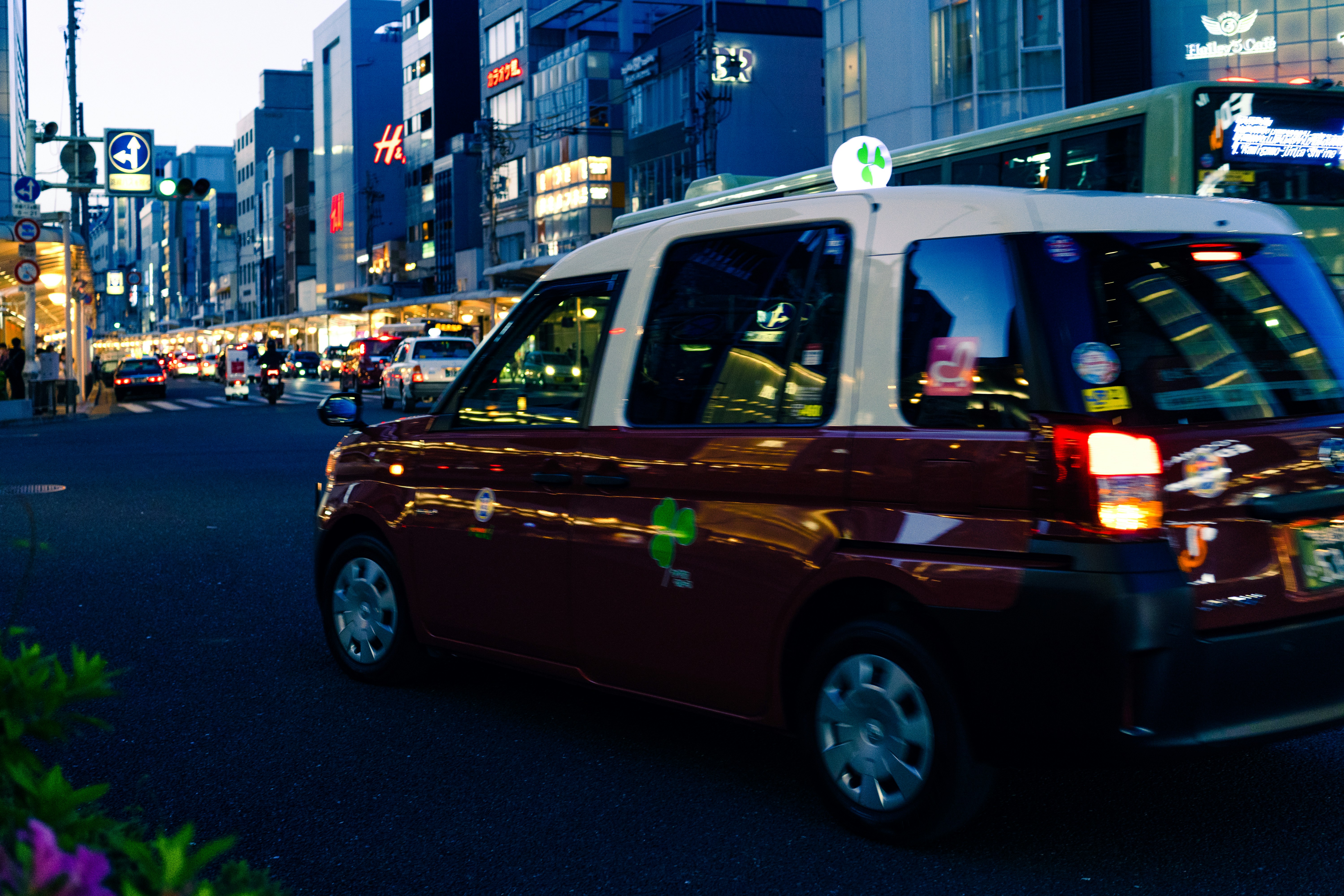 Kyoto taxi driving along bustling city street at dusk