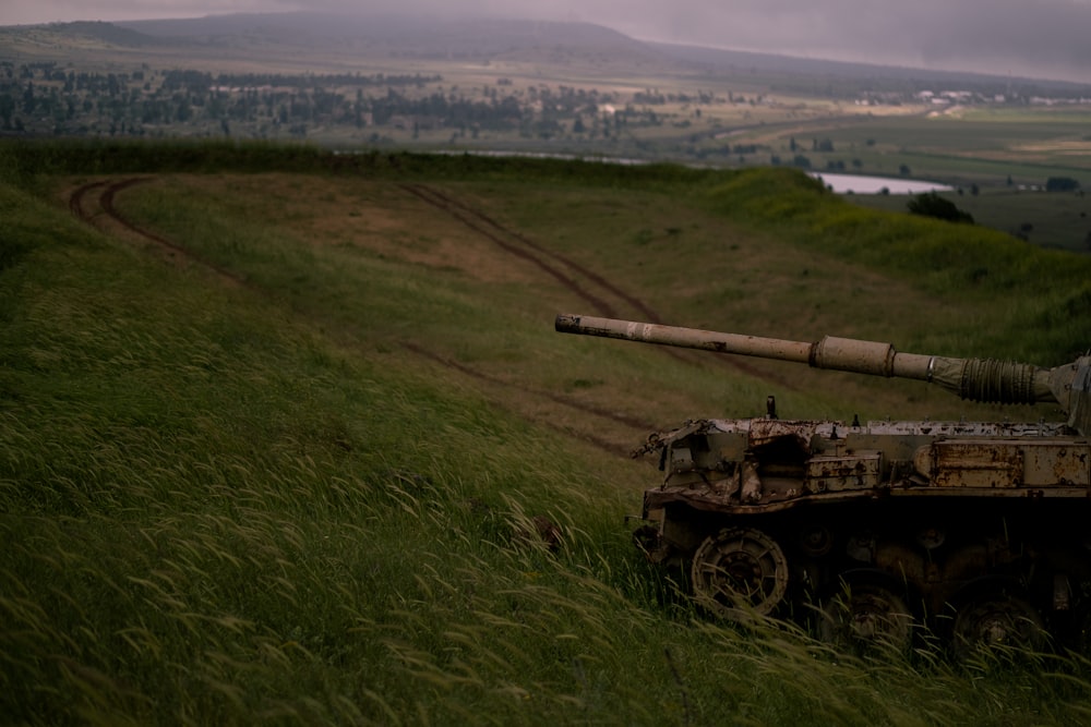 a military tank driving through a field