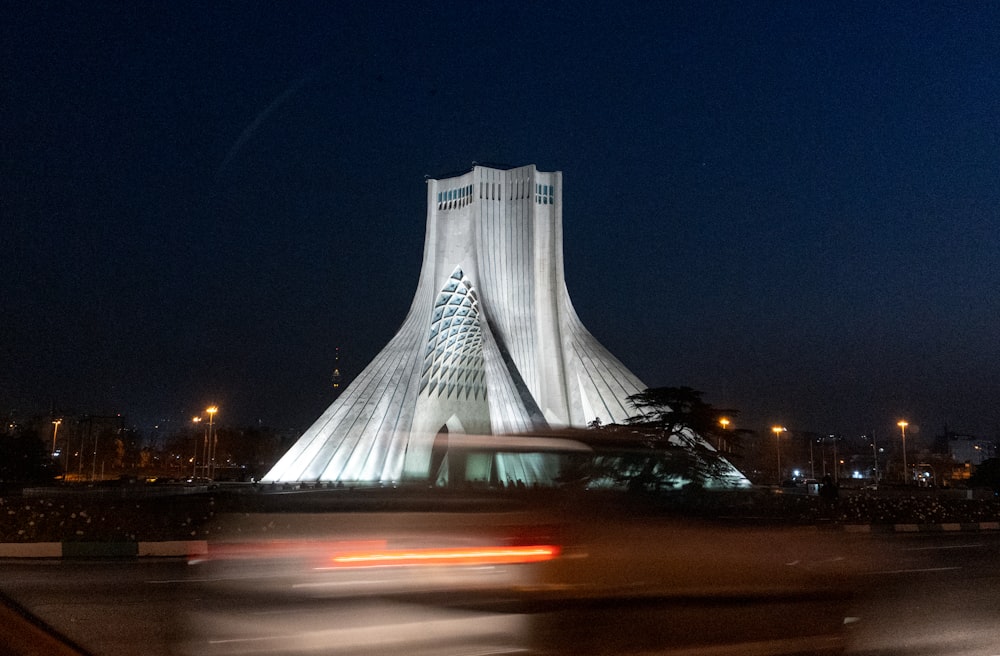 ein großes pyramidenförmiges Gebäude mit Azadi-Turm im Hintergrund