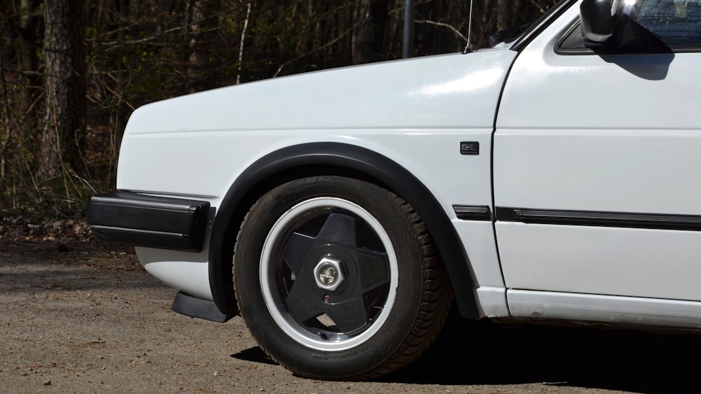 a white car parked on a dirt road