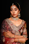 Stylish ensemble featuring a woman in a cream and antique gold festive outfit accented with traditional Indian jewelry.