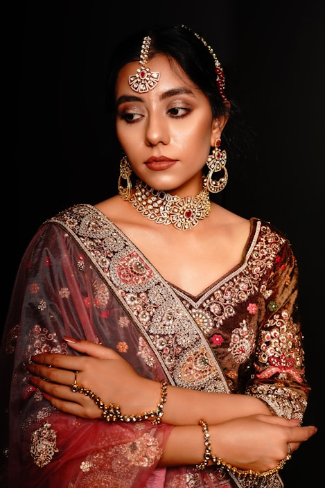 A vibrant display of premium Indian-inspired women's garments with rich fabrics and intricate embroidery.