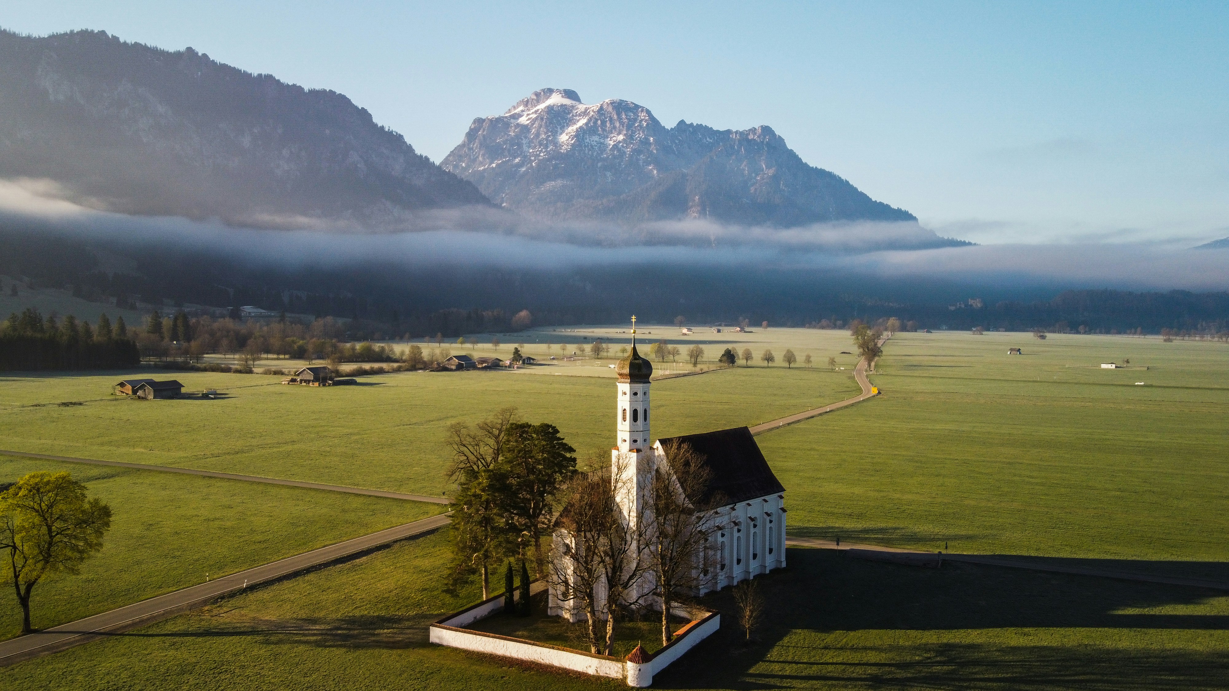 Ein Gebäude auf einem Feld mit einem Berg im Hintergrund