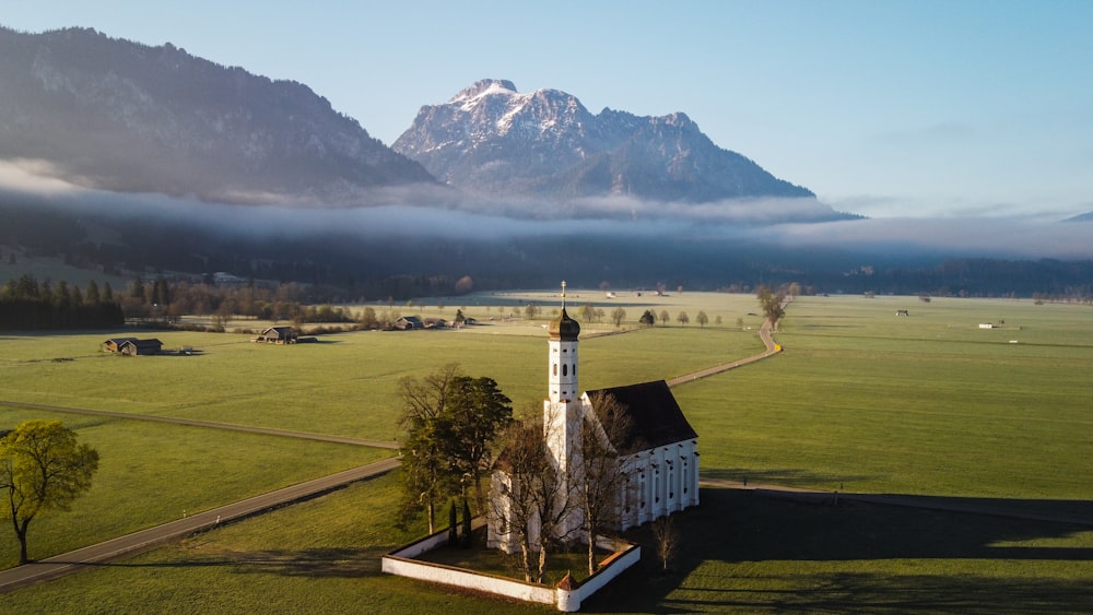 a building in a field with a mountain in the background