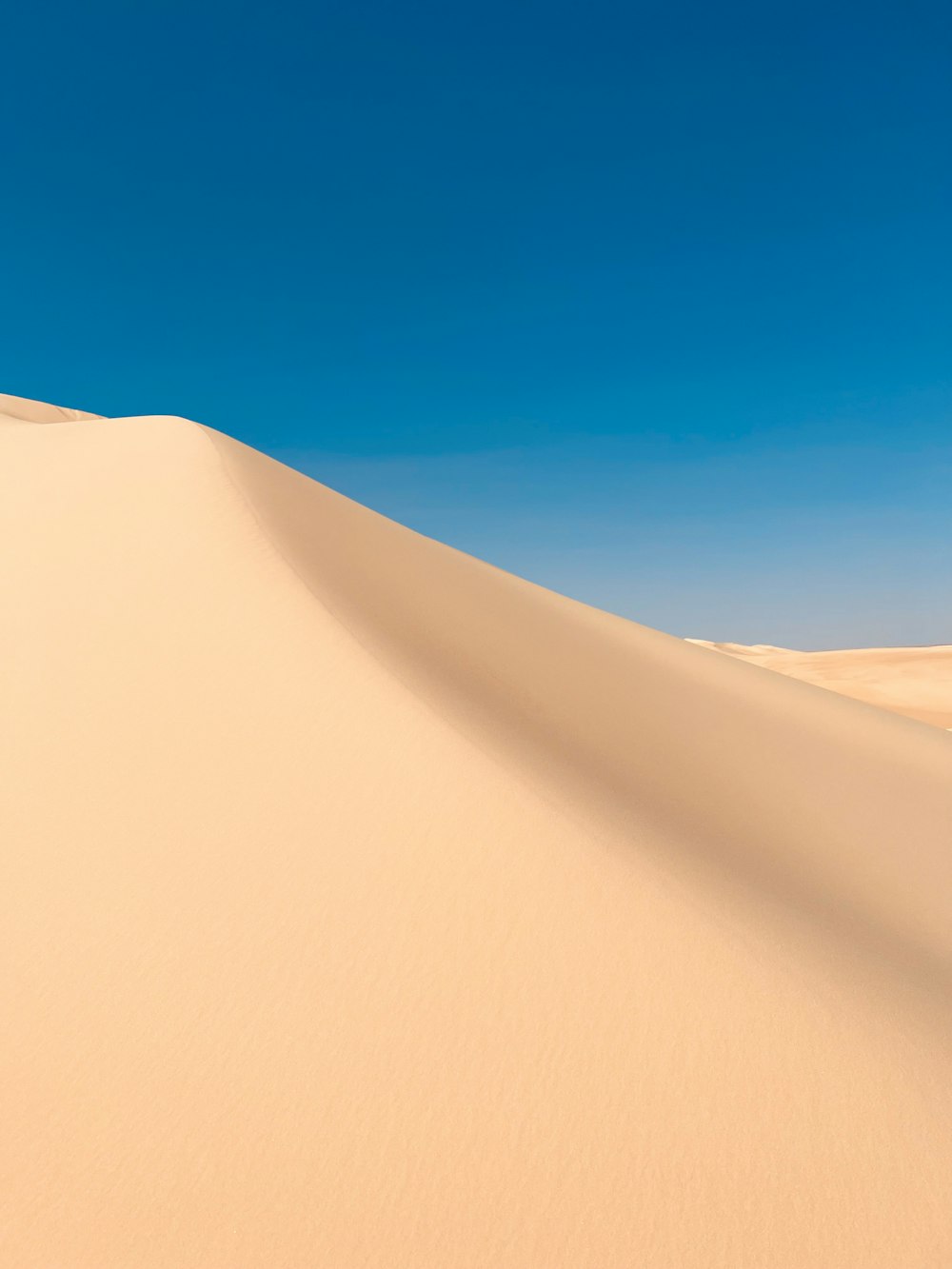 a sand dune under a blue sky