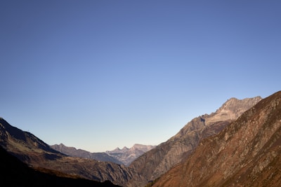 A wide-angle view of a mountain range under a clear blue sky.