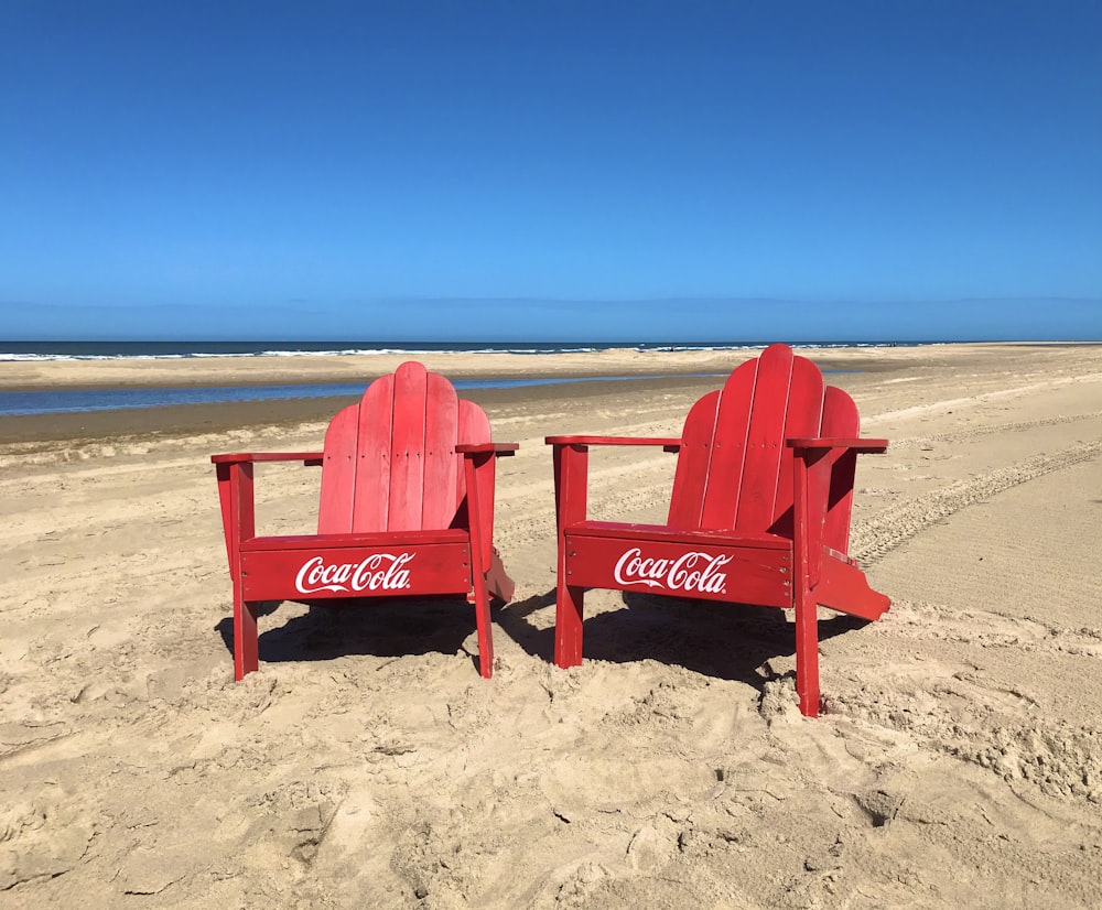 two red chairs on a beach