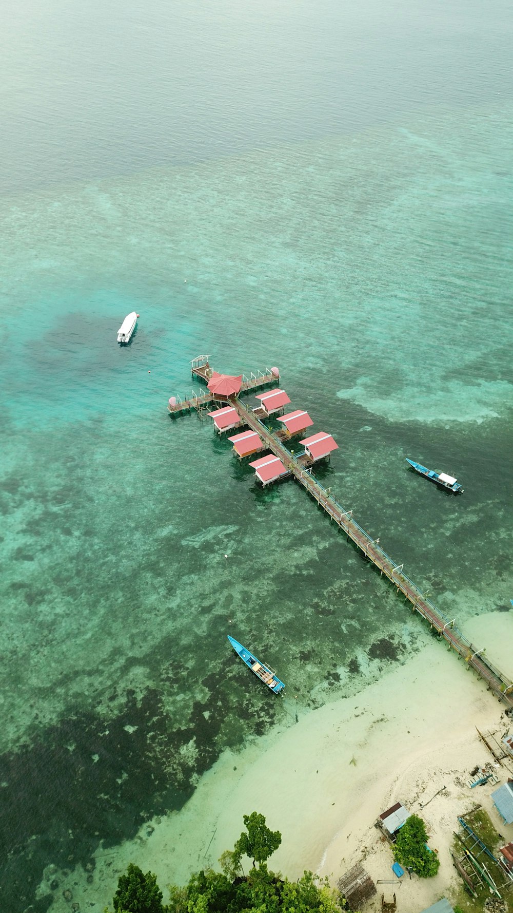 a group of boats sit on the shore of a beach