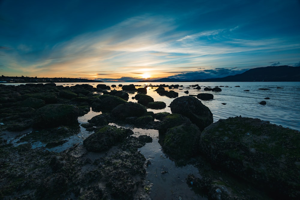 Ein felsiger Strand mit Sonnenuntergang